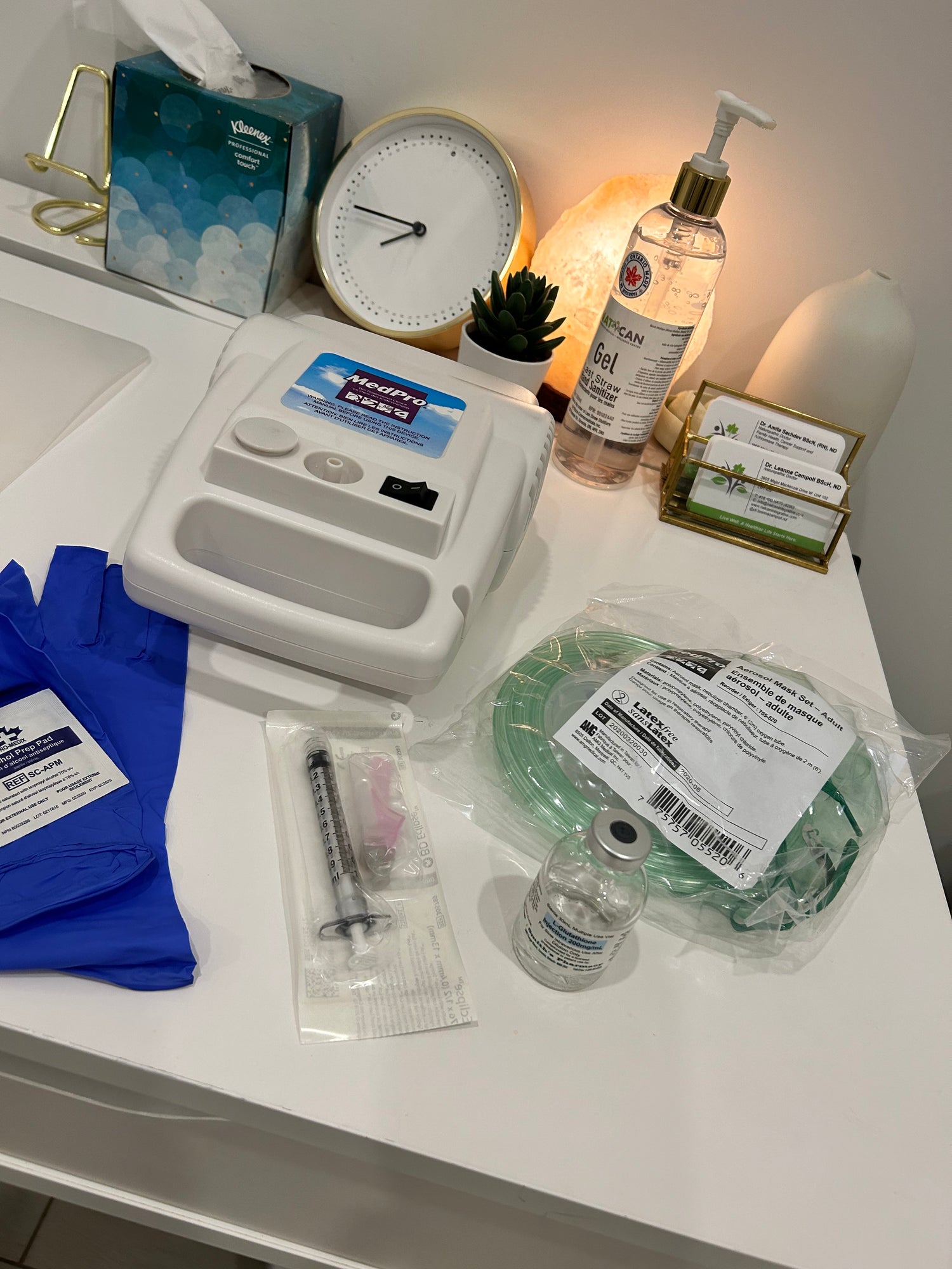 A health care table is covered with various treatment tools, including a syringe, latex gloves, and a tube. These items are designed to treat asthma and other chronic illnesses.