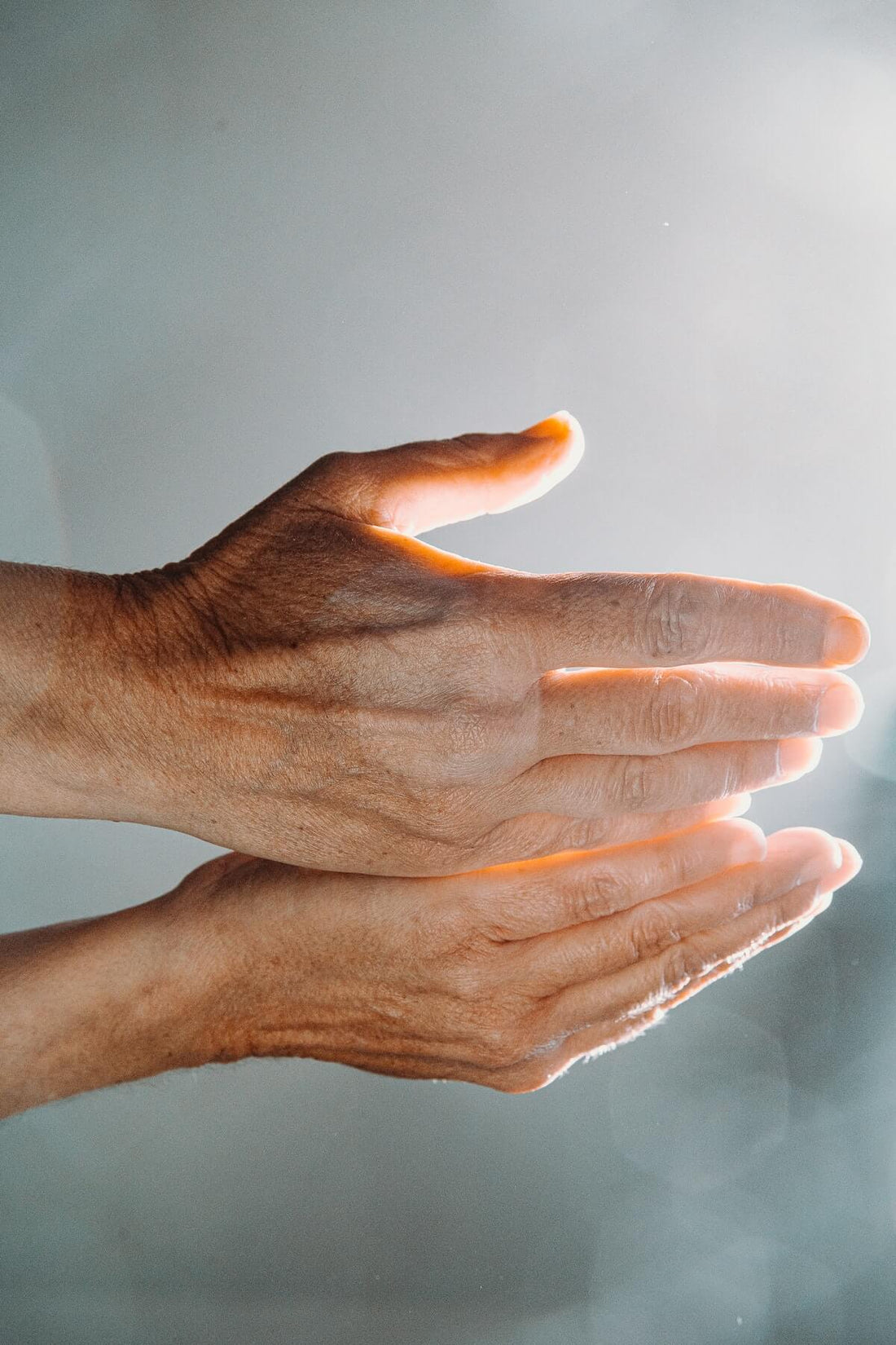 A person holds out their hands to feel a ray of light on their palms. This is part of an energy medicine treatment to help with anxiety, stress, and depression.
